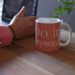 woman with laptop and mug of coffee writting intentional goals for 2025